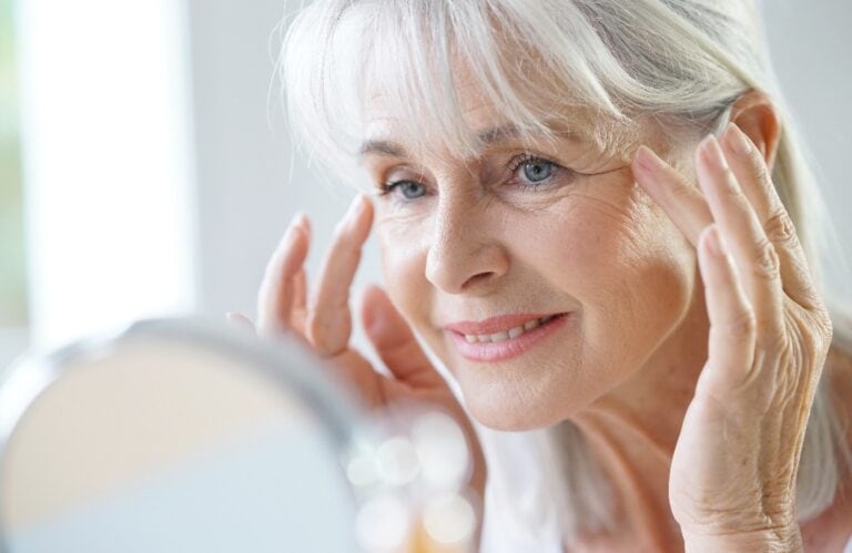 Portrait of senior woman applying anti-aging cream